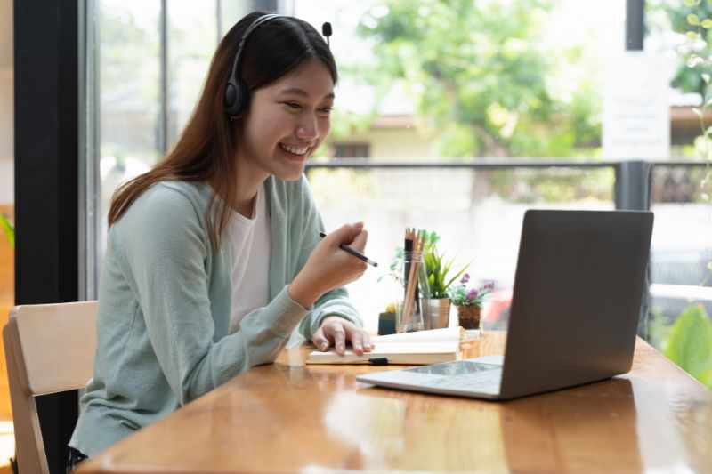 female student sitting at a laptop on an online lesson